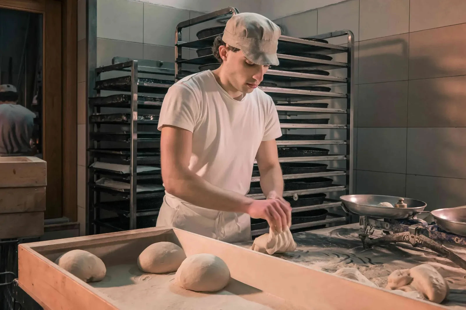 Fornaio durante la lavorazione manuale delle pagnotte di pane